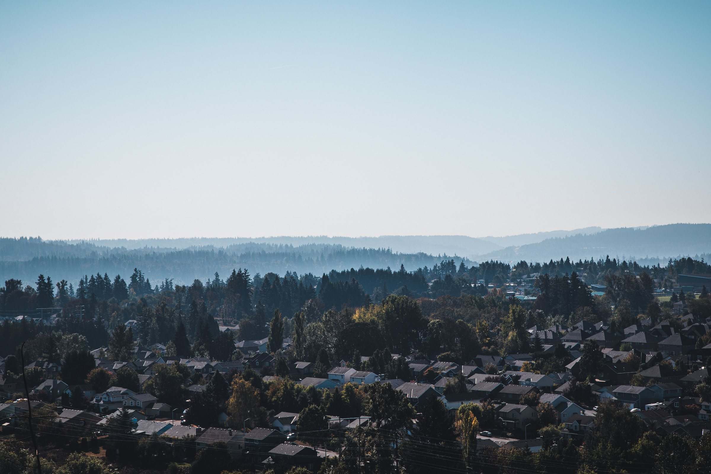 Happy Valley neighborhoods from above, with forested hills behind